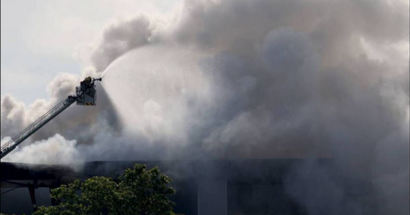 Nuvem de fumaça Imagens de bombeiros em cima da escada, apagando o grande incêndio retratado na matéria