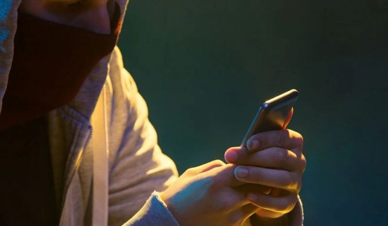 Homem de roupa amarela mexendo no celular Acusado disse à polícia que furtou o dinheiro por estar sendo ameaçado por agiotas