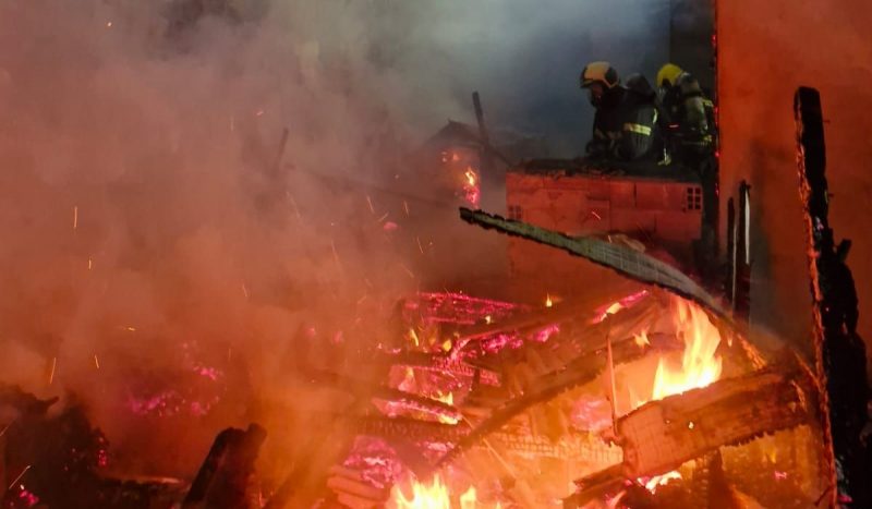 Incêndio mata idoso e destrói edícula em Lages Incêndio mata idoso e destrói edícula em Lages, foto mostra construção pegando fogo, já destruída, bombeiros aparecem ao fundo