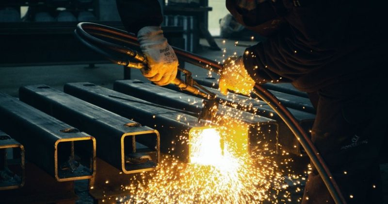 Metalurgia Imagem de uma pessoa realizando um trabalho de metalurgia, para fazer referência ao foco das indústrias que foram destaques no estado