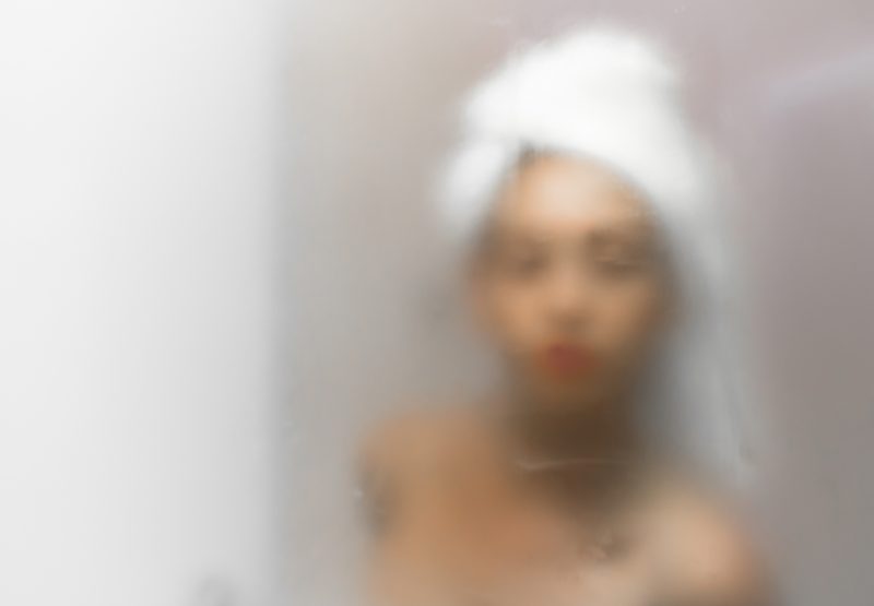 Mulher saindo do banho e olhando no espelho embaçado