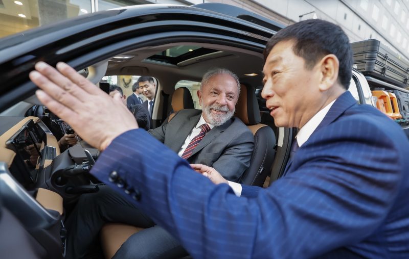 Lula dentro de carro ao lado de empresário chinês