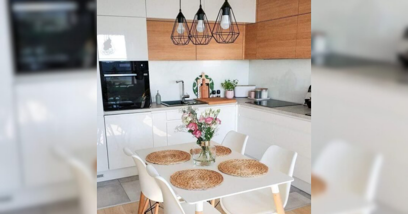 Cozinha clara, com uma mesa quadrada e luminária preta, para mostrar como uma sala de jantar ficaria com a lâmpada dessa cor 