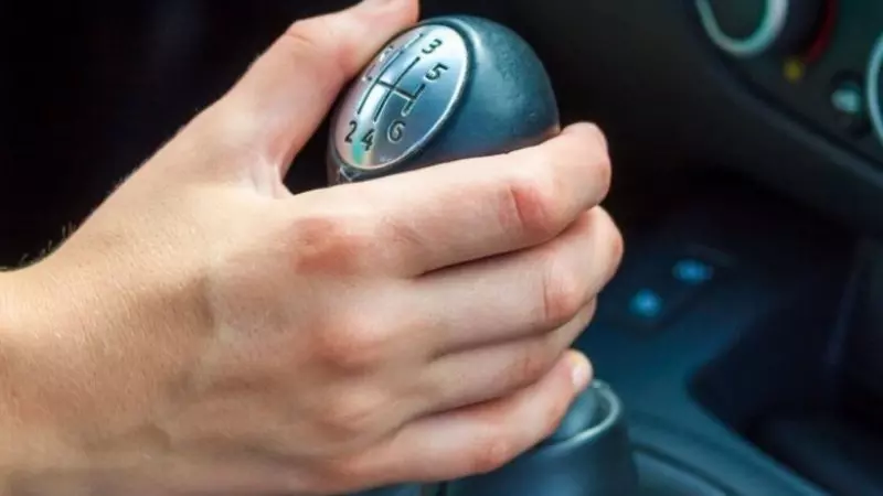 na foto aparece uma mão na marcha manual tentando dar velocidade ao carro na foto aparece uma mão na marcha manual tentando dar velocidade ao carro