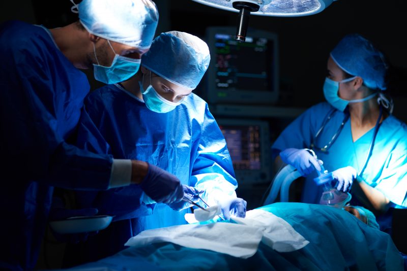 Médicos no centro cirúrgico Médicos e cirurgiões usam roupas verdes ou azuis