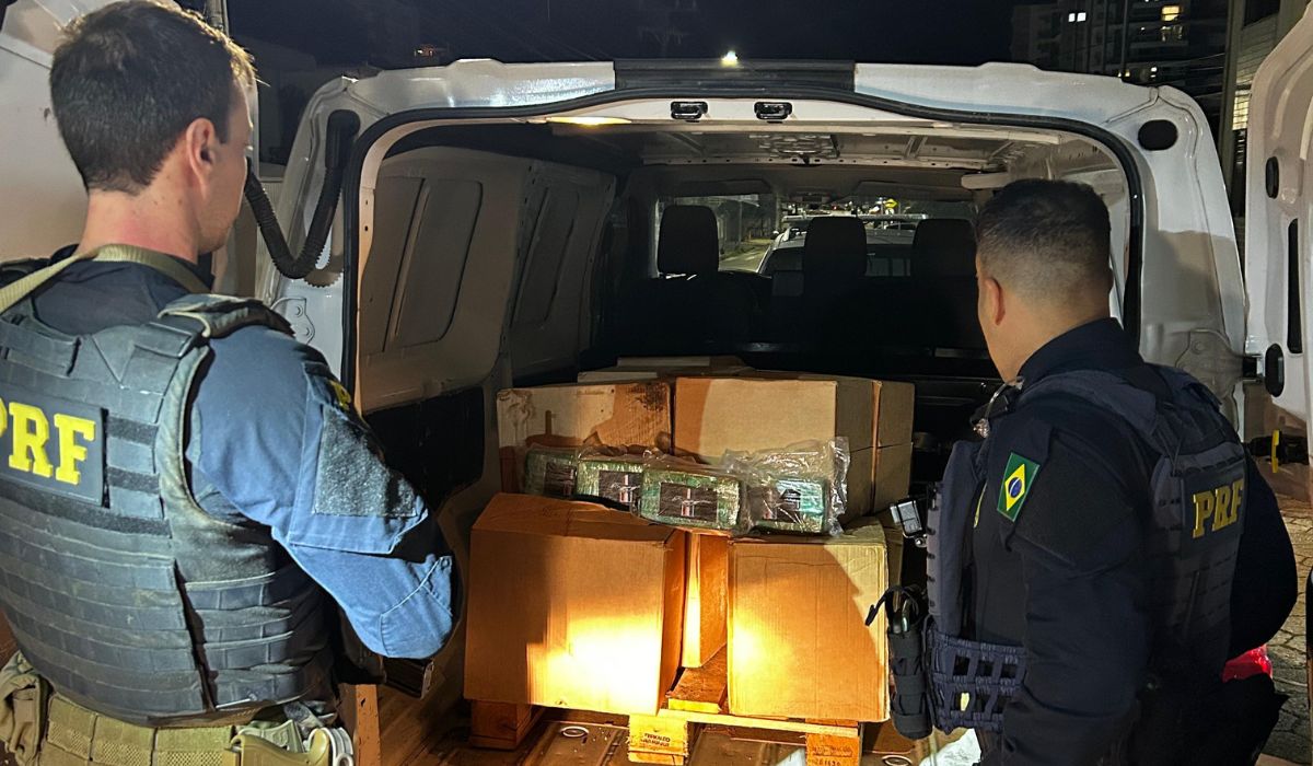 431kg de cocaína paraguaia apreendidos, foto mostra policiais olhando para caçamba de furgão com caixas