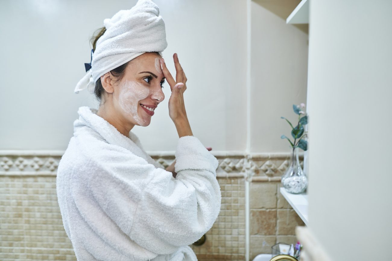 Mulher fazendo skincare Mulher fazendo skincare e passando hidrante no rosto após o banho