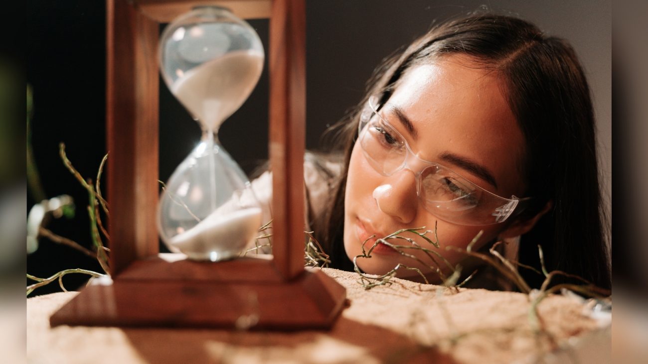 Pessoa olhando ampulheta e vendo tempo passar