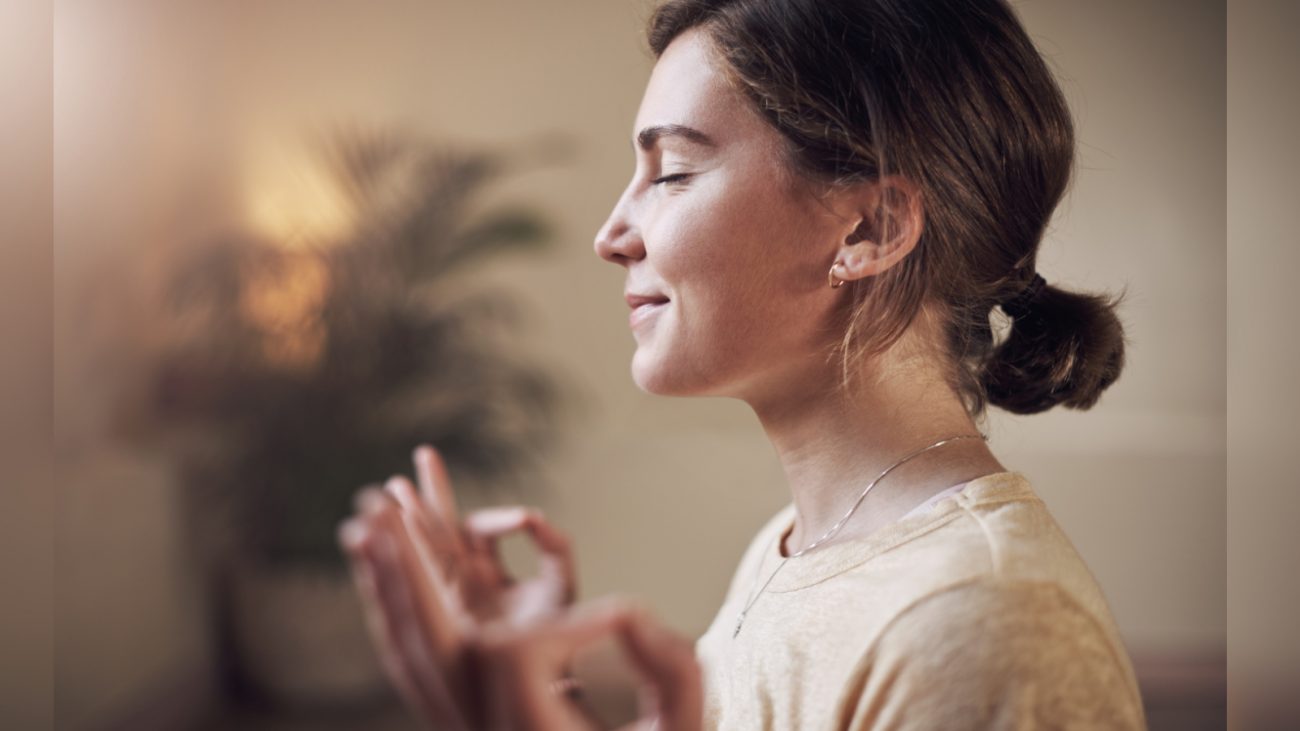 Imagem de mulher meditando com olhos fechados e dedos em circulos