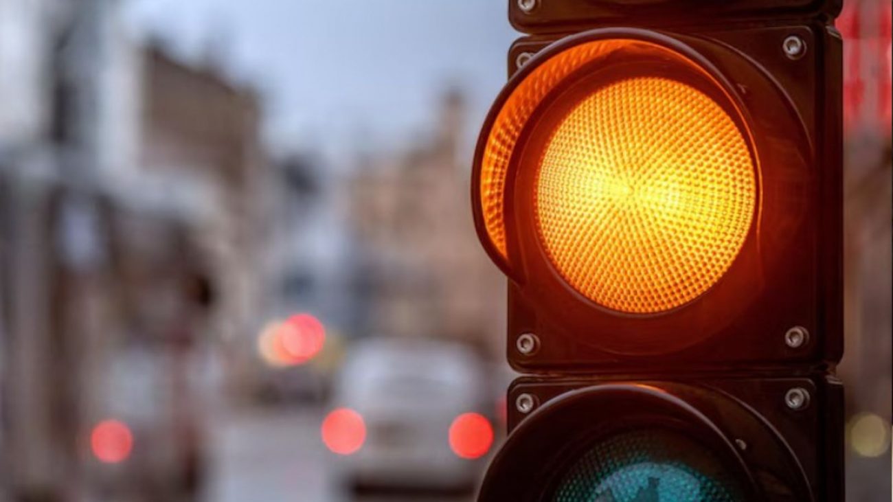 na foto aparece o trânsito que vai parar ao tentar passar no sinal amarelo
