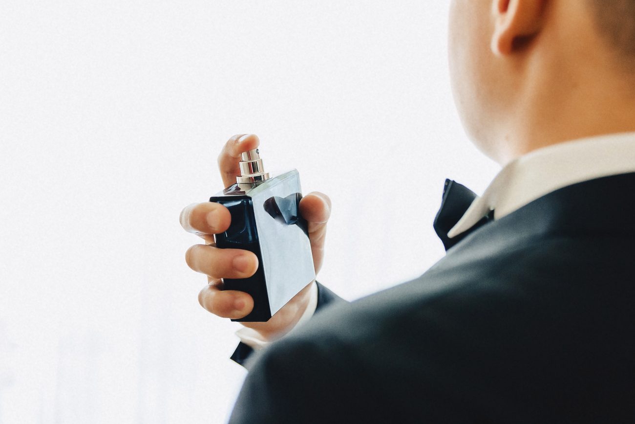 Homem passando perfume 