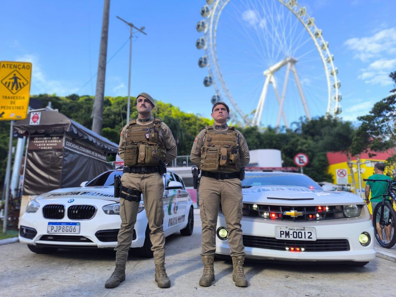 Policiais militares Imagem de dois policiais e de duas viaturas em frente à roda gigante para ilustrar matéria sobre a diminuição de homicídios na cidade