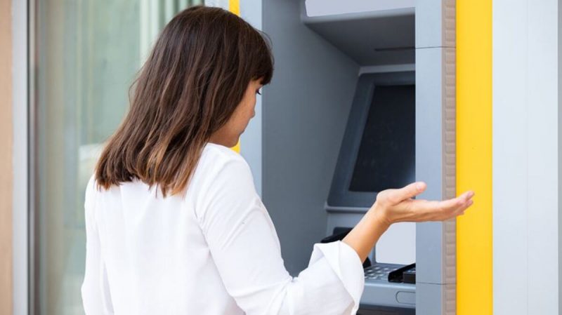 caixa eletrônico Mulher com o cartão preso no caixa eletrônico