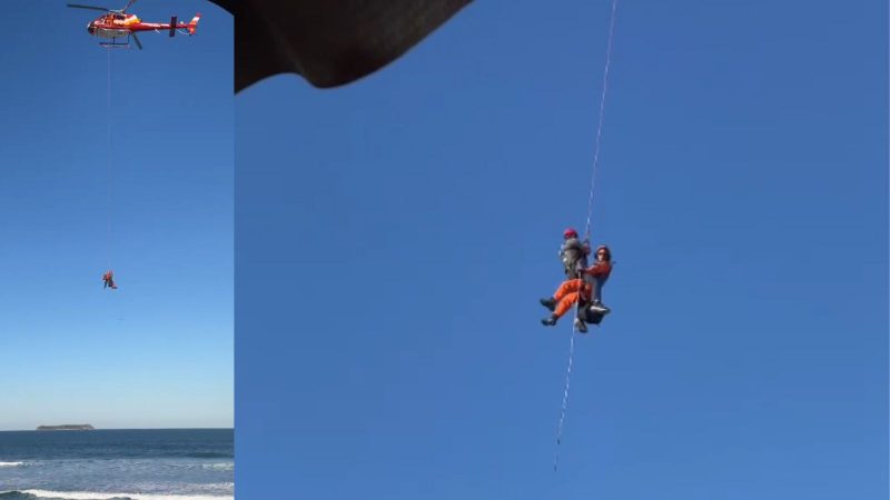 Imagens do resgate da vítima Imagem mostra que passeio de parapente quase termina em tragédia em costão perigoso de Florianópolis. Na foto está o helicóptero do corpo de bombeiros fazendo o resgate aéreo da vítima agarrados por uma corda pendurada no helicóptero.