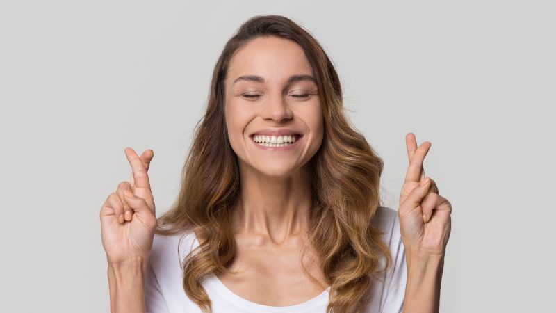 Ritual para atrair boa sorte Mulher cruzando os dedos para matéria sobre ritual para atrair boa sorte