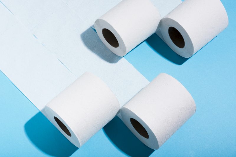 Papéis higiênicos Papéis higiênicos rolando sobre um fundo azul