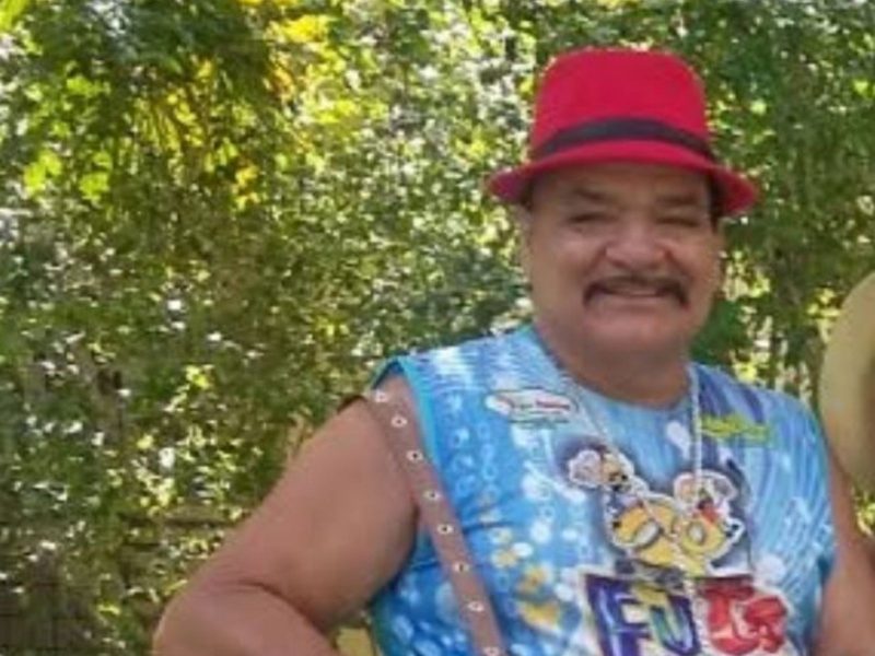 Tony Marreta Imagem mostra um homem de chapéu vermelho, vestindo uma regata na cor azul. Tony Marreta tem bigode, pele escura e está sorrindo para a foto. Ele morreu após bater em cerca de arame farpado e capotar o carro em Ascurra