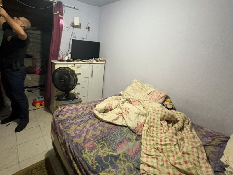 Imagem mostra quarto com cama desarrumada, televisão, ventilador e uma cômoda reviradas. Polícia Civil faz operação em Indaial após mulher ser ameaçada por tio em briga por terreno