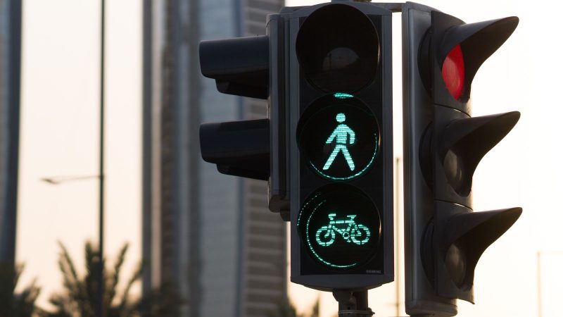 Pedestre deve ficar atento à sinalização! Imagem mostra um semáforo ou sinaleiro que indica a passagem para pedestre e ciclista.