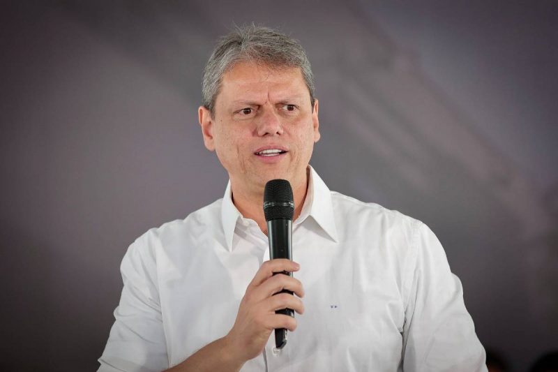 Tarcísio de Freitas Tarcísio de Freitas com microfone na mão e camisa branca
