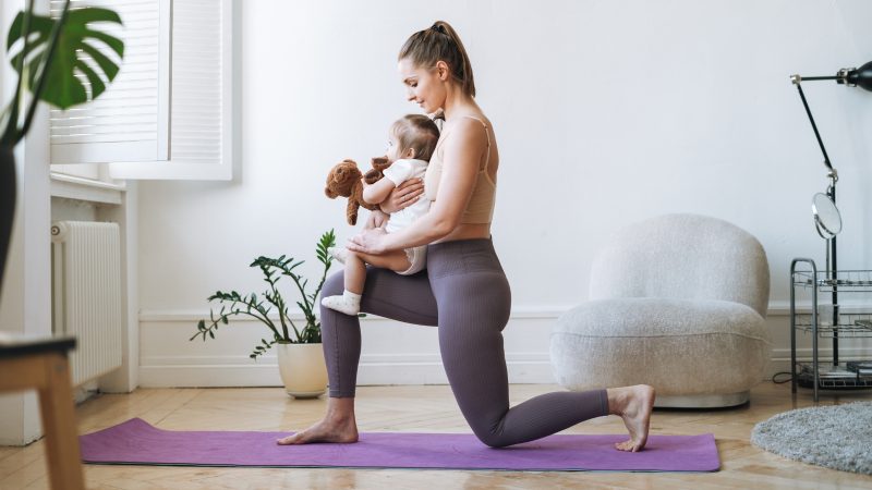 Mulher segurando bebê nos braços fazendo treino que faz barriga pós-parto desaparecer 