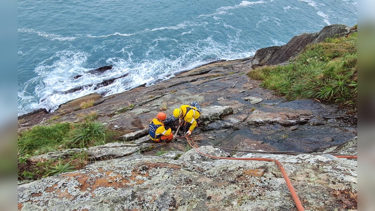 corpo encontrado entre pedras Pessoas escalando montanha para resgatar corpo encontrado entre pedras