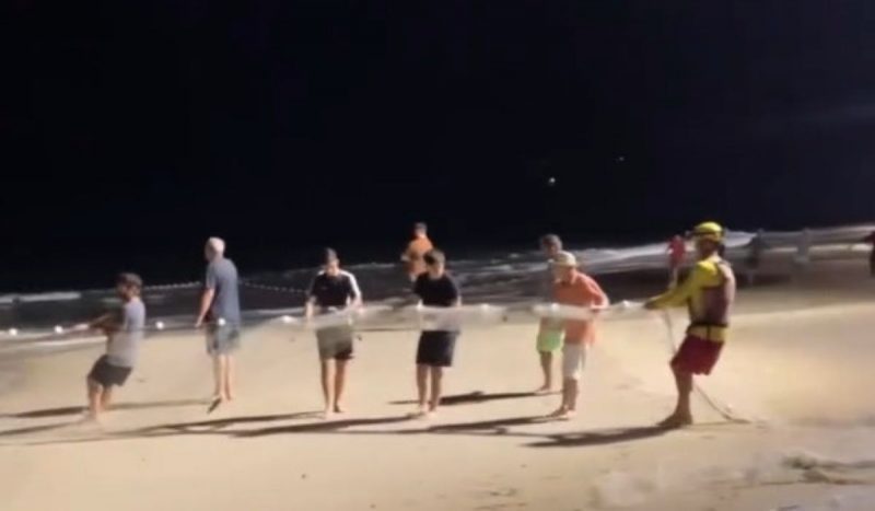 Pescadores tentam resgatar vítima com rede de pesca Pescadores tentam resgatar vítima com rede de pesca, foto mostra várias pessoas puxando rede