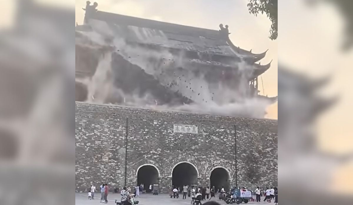 Telhado de torre de 650 anos desaba na China Telhado de torre de 650 anos desaba na China, foto mostra parte de telhado caindo em cima de edifício, com poeira branca em volta e turistas abaixo correndo e olhando para cima
