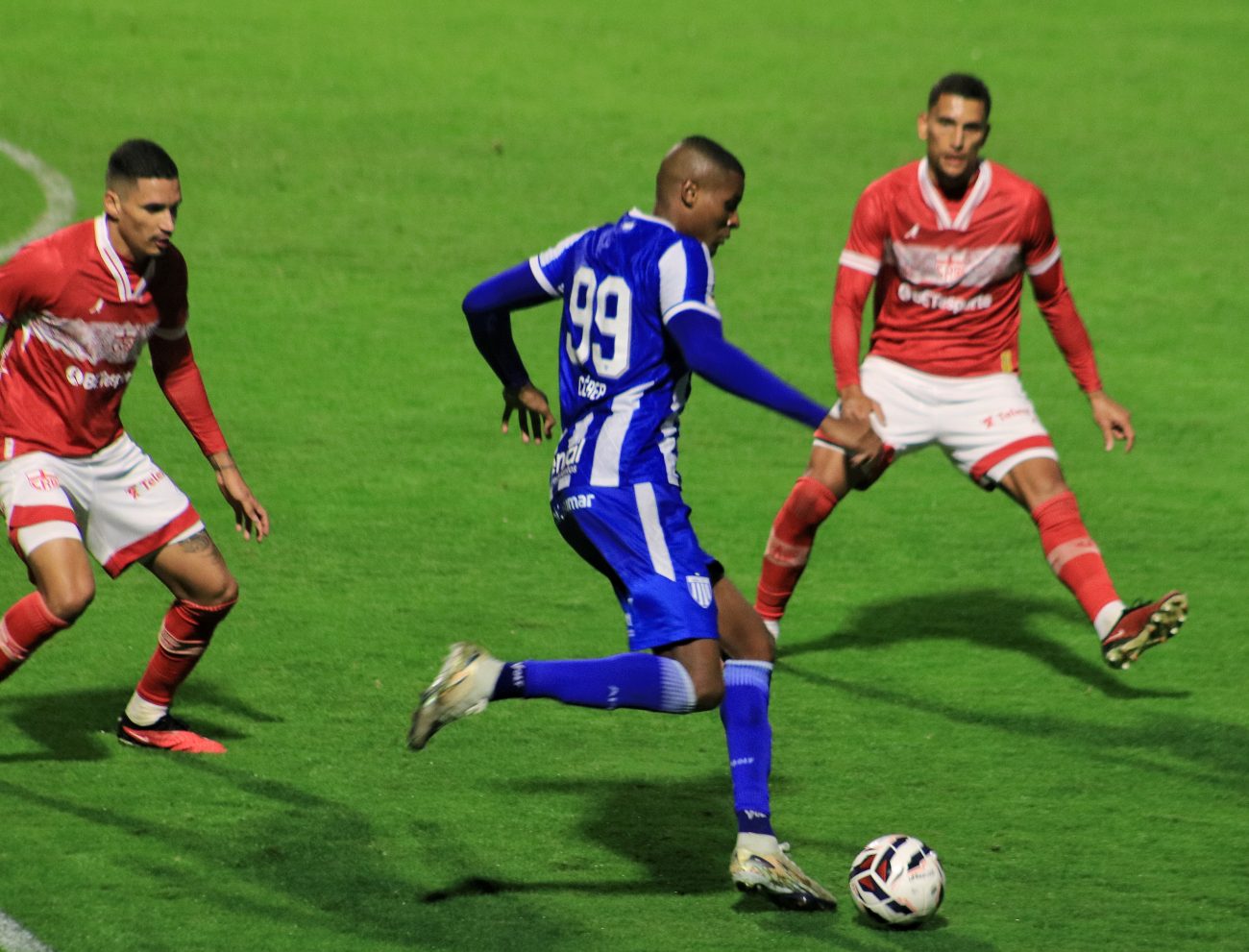 Cléber, do Avaí, sendo marcado por dois jogadores do CRB