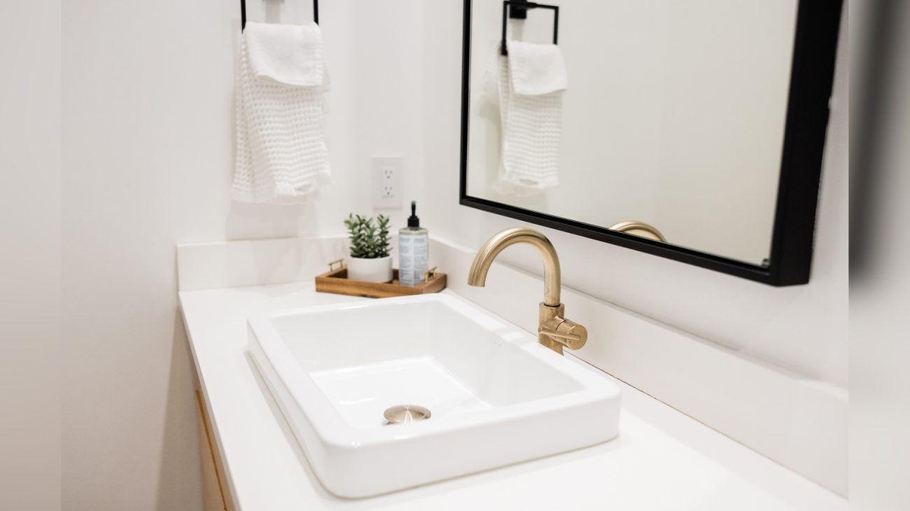 Imagem de banheiro com plantas e toalhas e espelhos com torneira