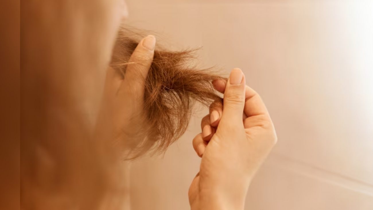 Mulher segurando cabelo seco nas mãos