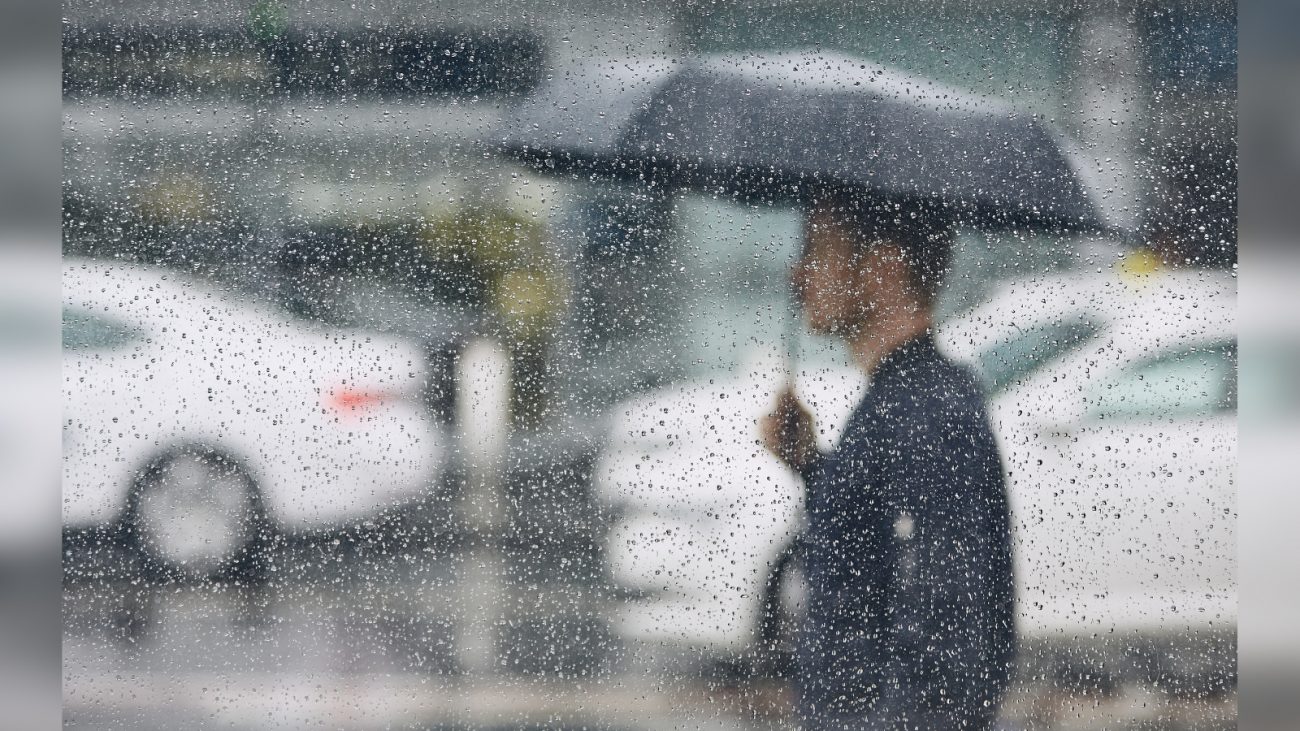 Homem andando com guarda-chuva durante a chuva