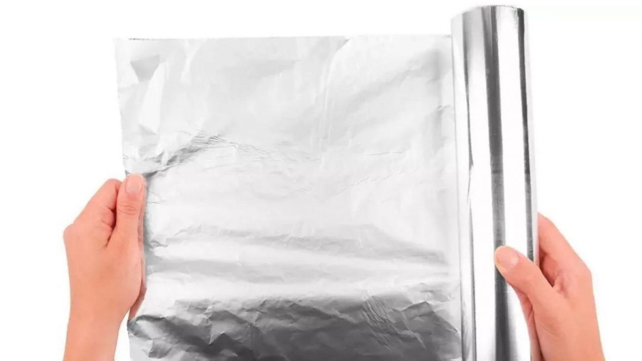 na foto aparece alguém abrindo um rolo de papel alumínio e pensando em ficar enrolando os braços e as pernas no papel alumínio