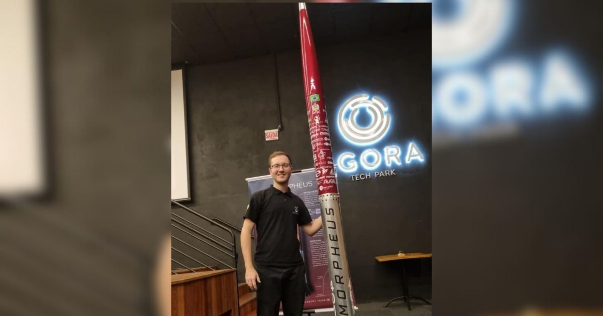 Imagem do estudante da UFSC com um foguete na mão, pata faZ referência a competição mundial de foguetes que ele vai nos EUA 