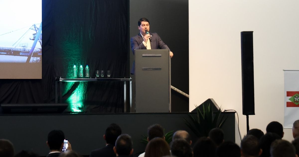Imagem de um homem fazendo um discurso no ato de assinatura, para fazer referência a todos os projetos que o plano de energia limpa possue 