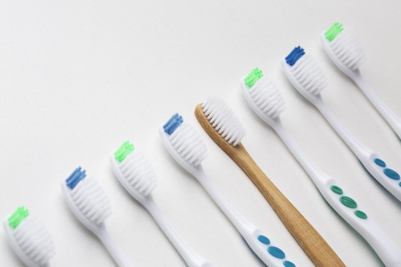 Diversas escovas de dentes com os detalhes coloridos em um fundo branco