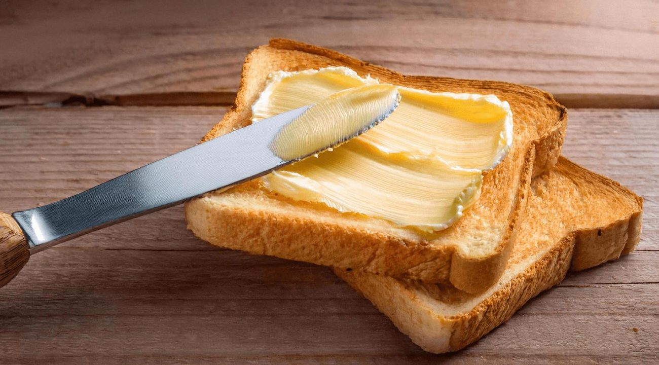 Foto de um pão com margarina. Conteúdo que diz que a margarina é mais saudável que manteiga.