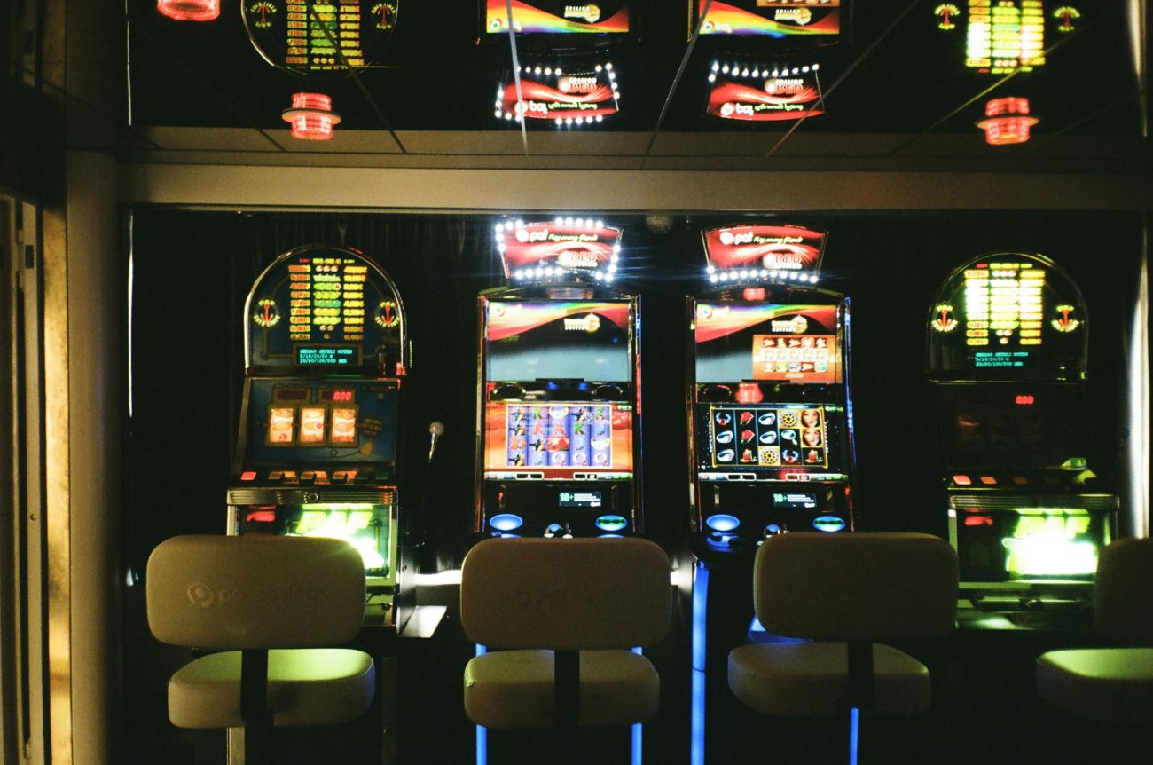 Caça-níqueis um do lado do outro em um ambiente escuro. Conteúdo discute se existe melhor hora para jogar slots.