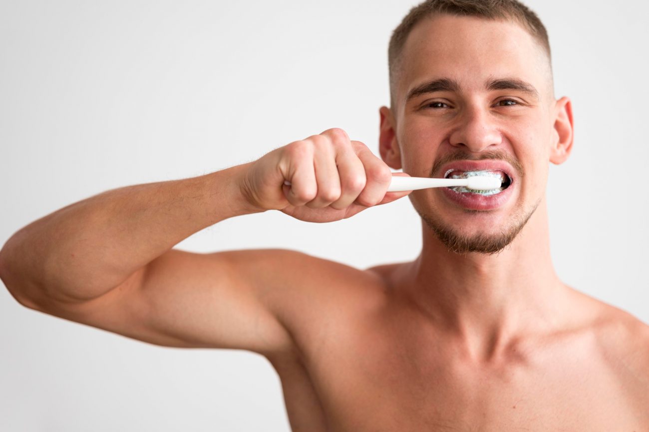 na foto homem aproveita o momento ideal do dia para escovar os dentes