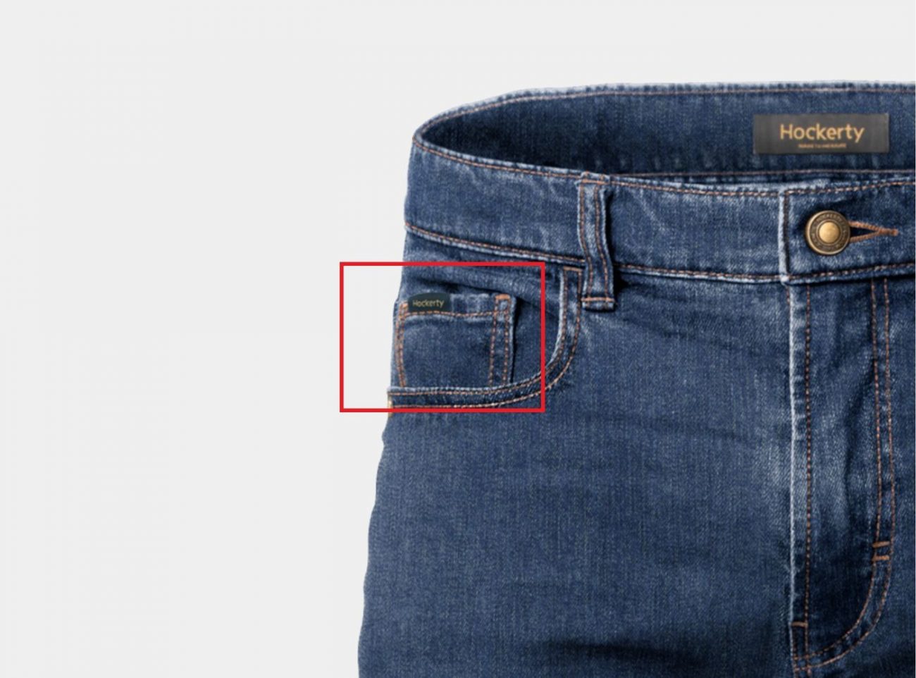 Close-up de uma calça jeans da marca Hockerty com foco no mini bolso costurado