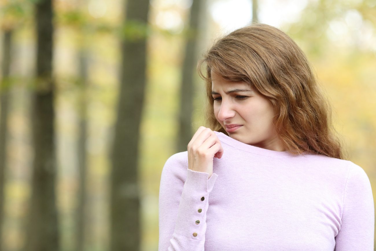 Mulher sentindo cheiro de mofo nas roupas de inverno