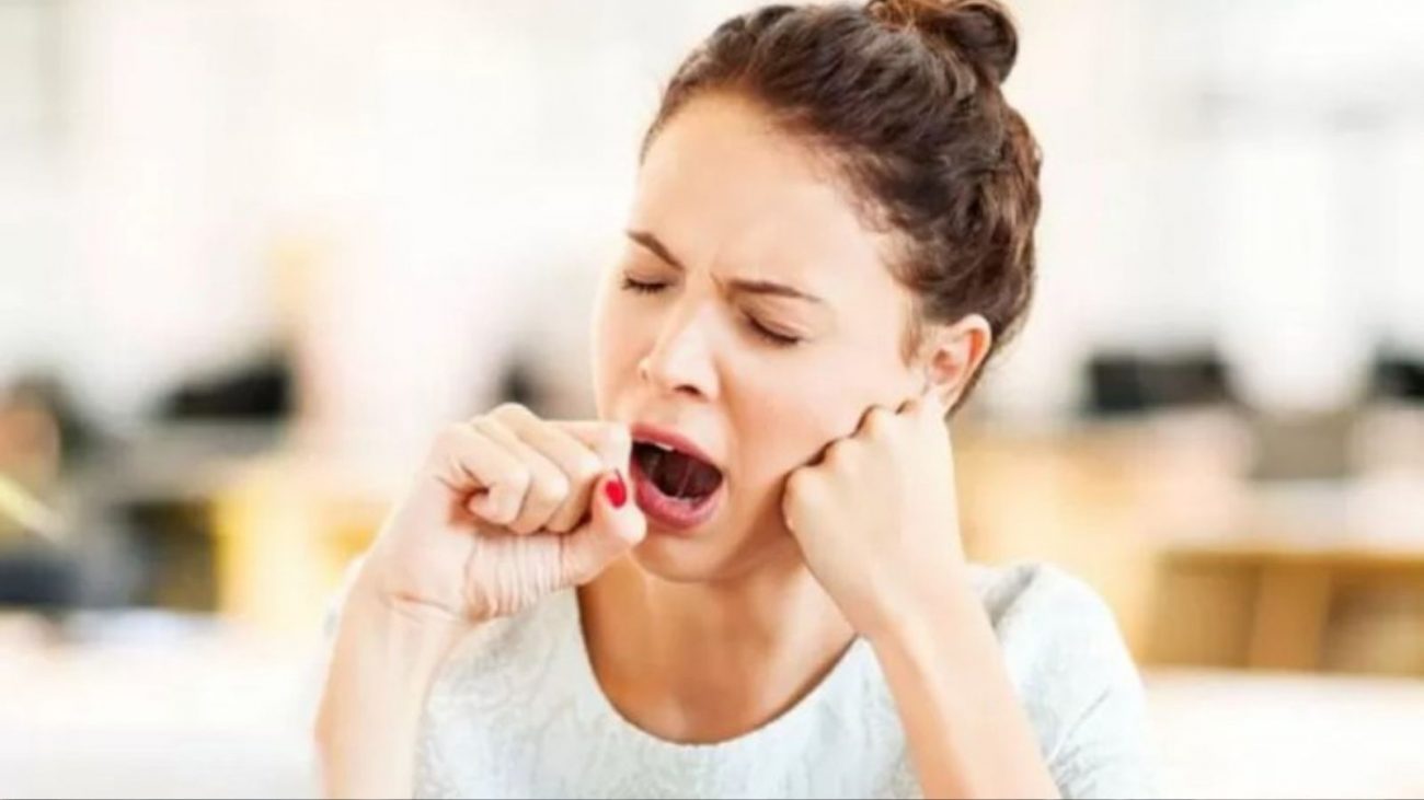 na foto aparece uma mulher bocejando com muito sono o dia todo