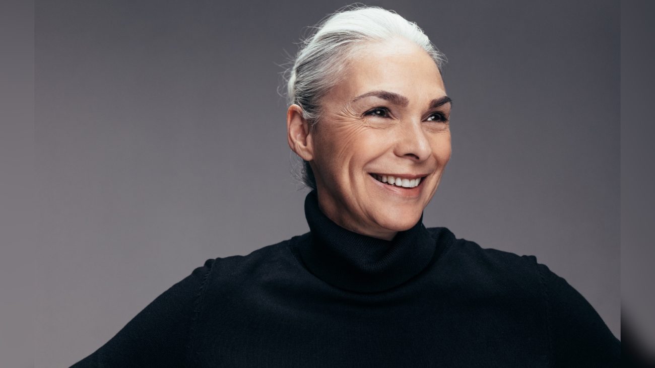 Imagem de mulher mais velha sorrindo de roupa preta