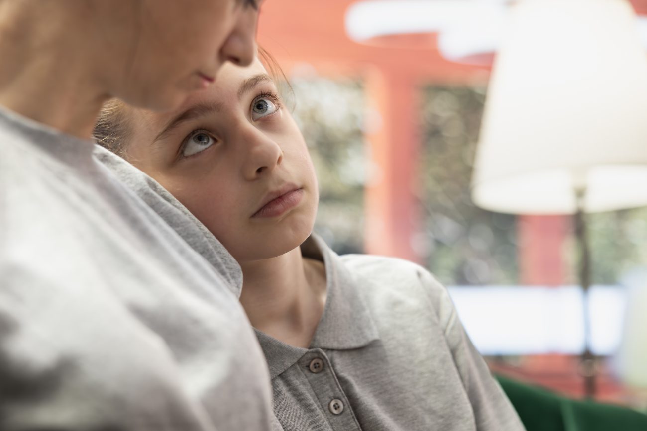 Adolescente olhando para a mãe, tentando entender suas feições