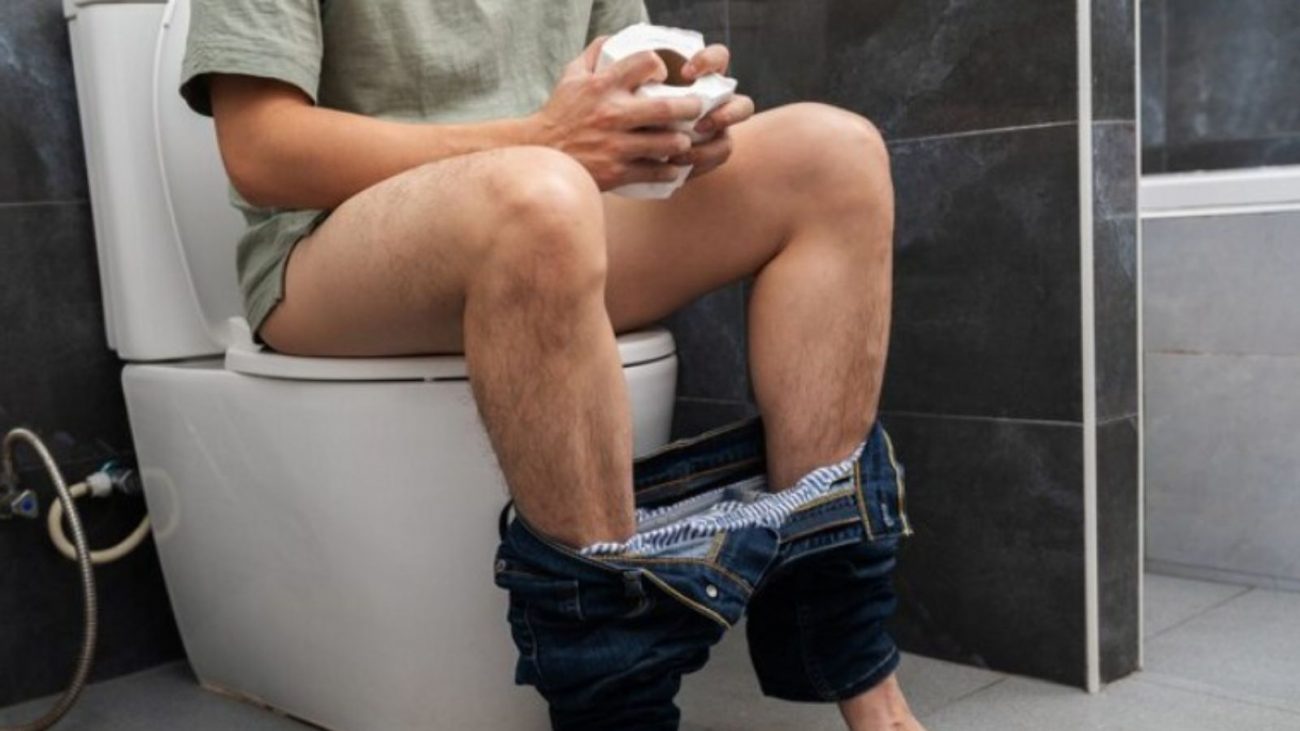 na foto aparece um homem no banheiro tentando ter uma digestão e cocô perfeitos