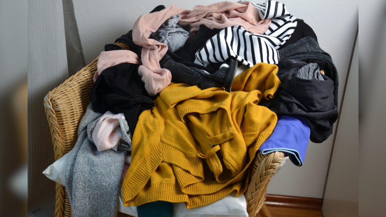 Imagem de pilha de roupas em cima de cadeira