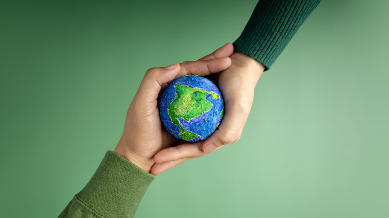 Pessoas segurando planeta Terra na mão