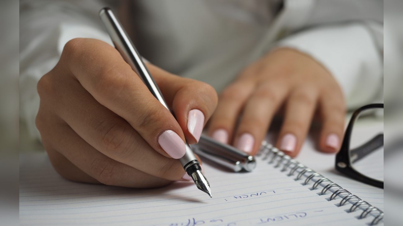 Aprenda o jeito certo de segurar a caneta. Posicione ela entre o polegar e o dedo indicador e, depois, utilize os outros dedos para apoiá-la e conseguir maior estabilidade. Além disso, é importante sentir a pressão quando segurar a caneta, sem segurar a caneta com uma pressão exagerada - Canva/ND