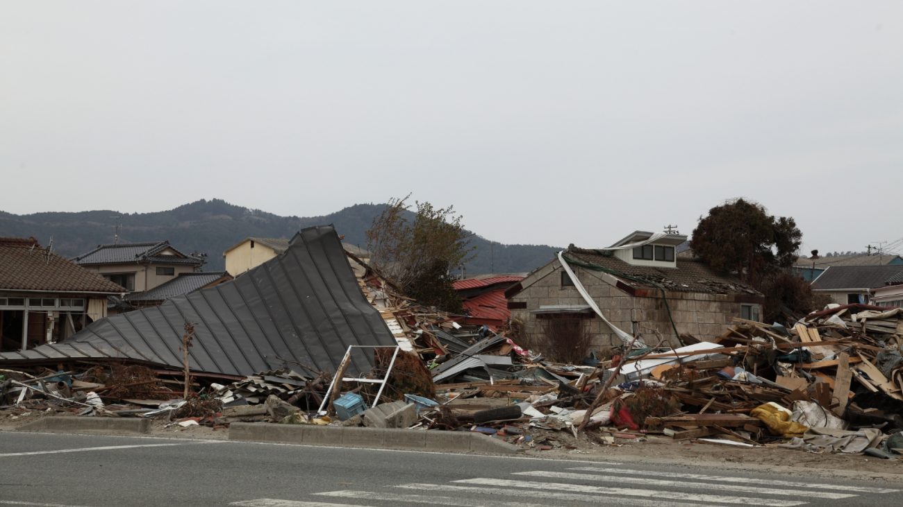 Imagem de local totalmente destruído com telhados de casa no chão