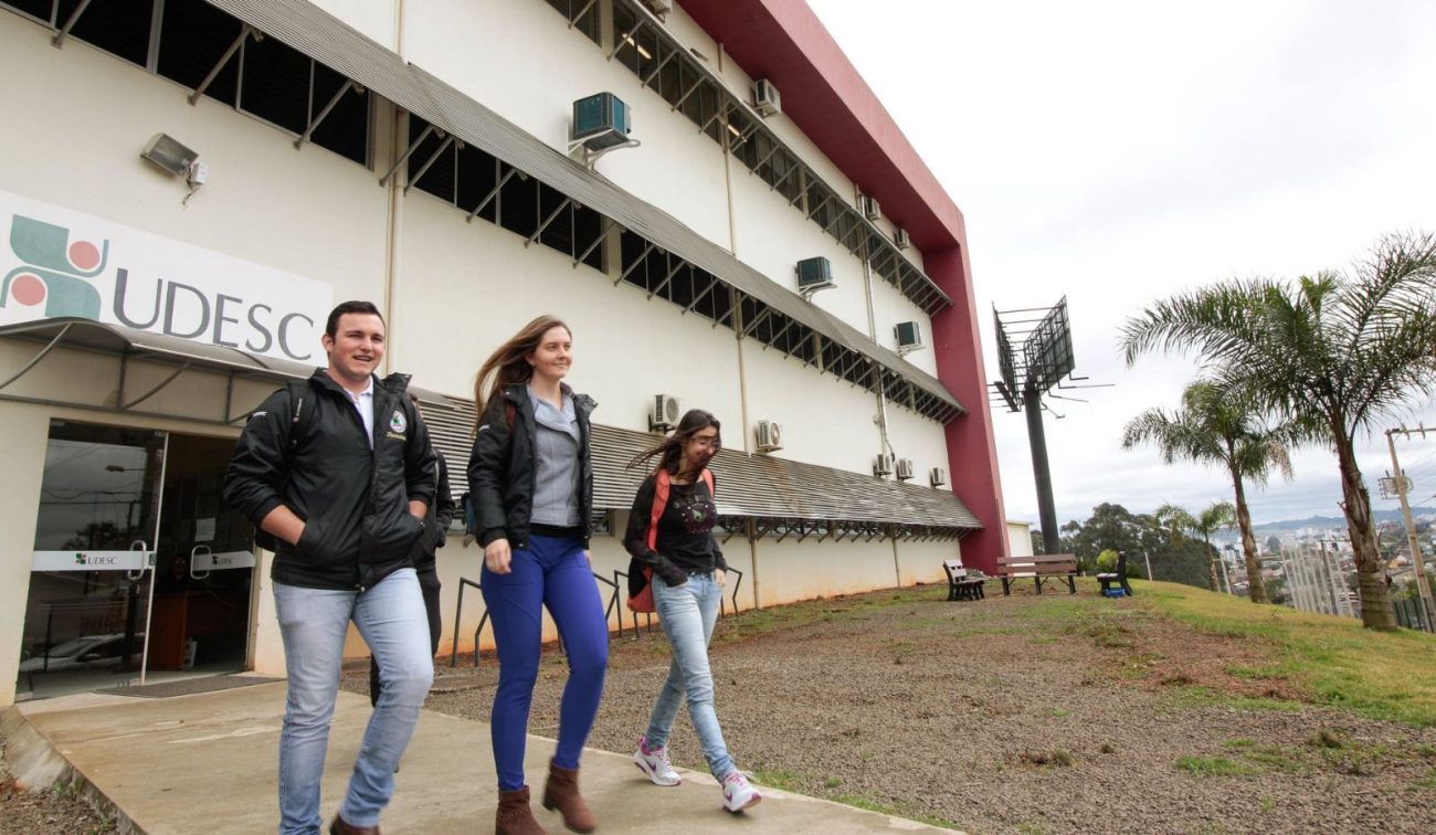 Estudantes caminham em frente ao prédio de uma universidade pública, local onde professores substitutos poderão atuar em diferentes áreas